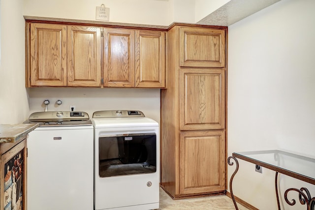 washroom featuring cabinet space and independent washer and dryer