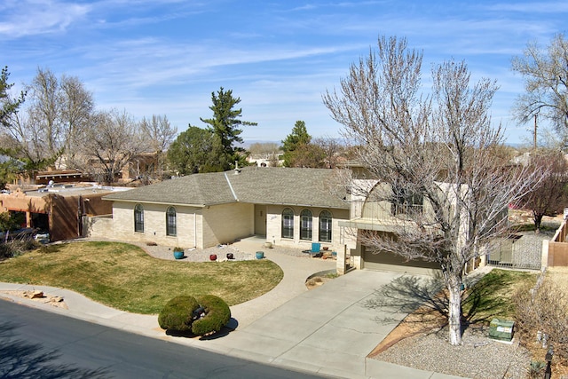 view of front of home featuring roof with shingles, fence, a garage, driveway, and a front lawn