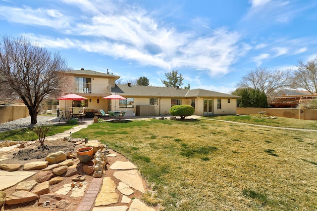 rear view of house featuring a patio area, a lawn, and fence