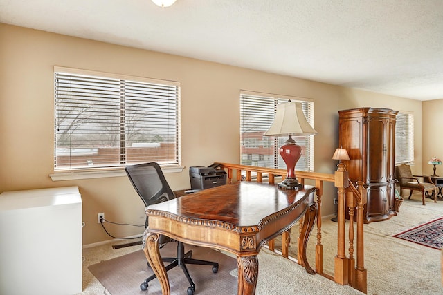 carpeted office with baseboards and a textured ceiling