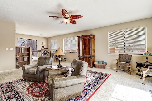 living room with carpet flooring, ceiling fan, a textured ceiling, and baseboards