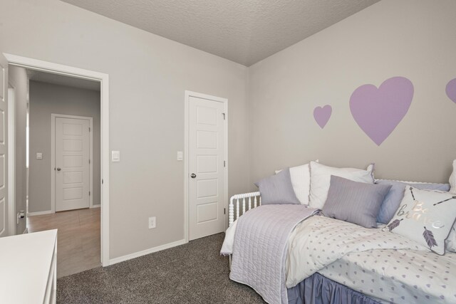 bedroom featuring a textured ceiling, carpet, and baseboards