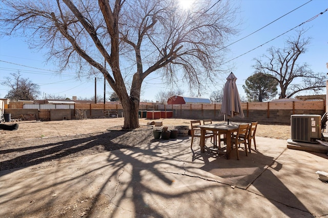 view of patio with central AC, outdoor dining space, and a fenced backyard