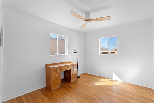 unfurnished office featuring ceiling fan, light wood-style flooring, and baseboards