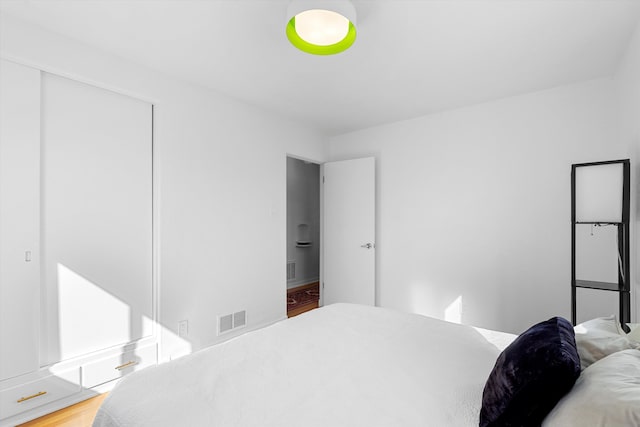 bedroom featuring light wood-style flooring, a closet, and visible vents