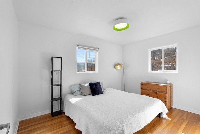 bedroom featuring baseboards and wood finished floors