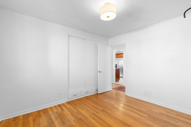 unfurnished room with light wood-type flooring and baseboards