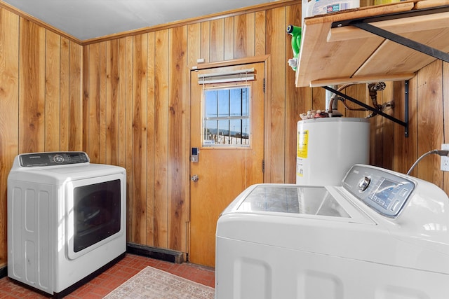 laundry area with brick floor, water heater, washing machine and dryer, wooden walls, and laundry area