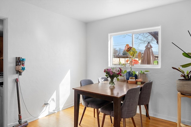 dining area featuring light wood-style flooring and baseboards