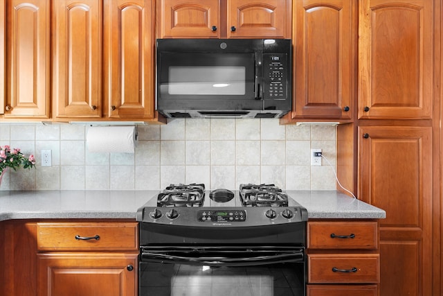 kitchen with decorative backsplash, brown cabinetry, light countertops, and black appliances