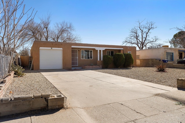 view of front of home with a garage, driveway, fence, and stucco siding