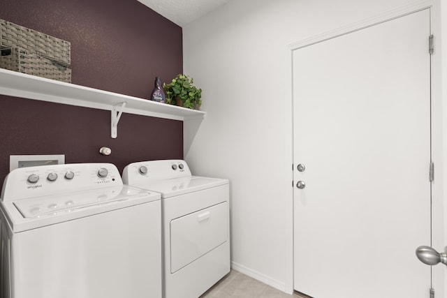 laundry area featuring light tile patterned floors, laundry area, and washing machine and dryer