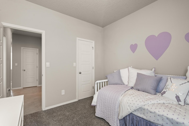 bedroom with a textured ceiling, baseboards, and carpet flooring