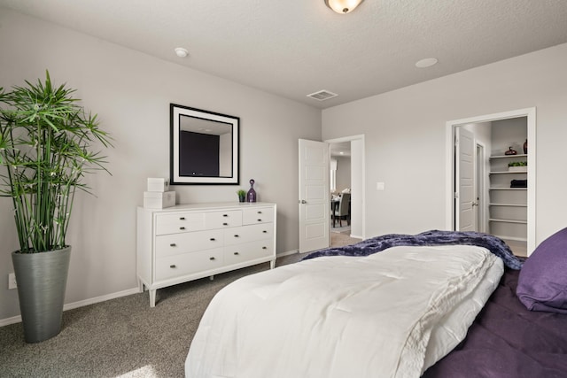 carpeted bedroom with baseboards, visible vents, and a textured ceiling