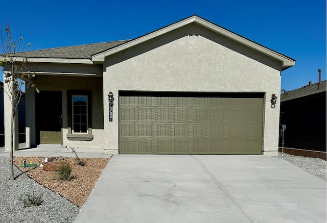 ranch-style home featuring driveway, a shingled roof, an attached garage, and stucco siding