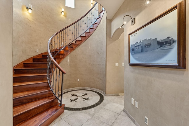 stairs with arched walkways and tile patterned flooring