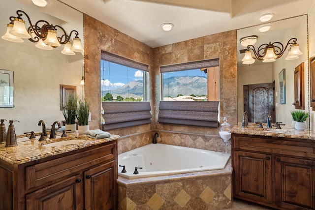 full bath featuring a jetted tub, a mountain view, two vanities, and a sink