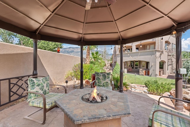 view of patio / terrace featuring a balcony, an outdoor fire pit, a mountain view, and a gazebo