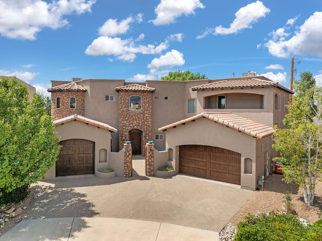 view of front facade with a garage, decorative driveway, and stucco siding