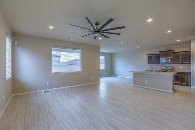 unfurnished living room featuring visible vents, baseboards, ceiling fan, a textured ceiling, and recessed lighting