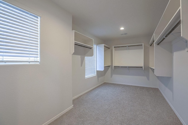 spacious closet with visible vents and light colored carpet