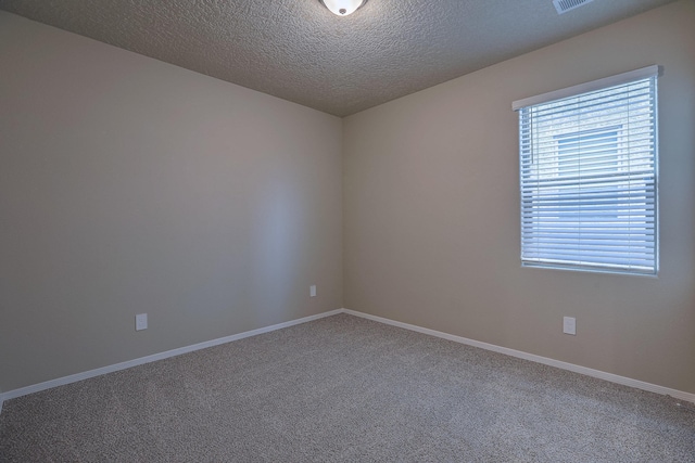 unfurnished room with carpet floors, a textured ceiling, and baseboards