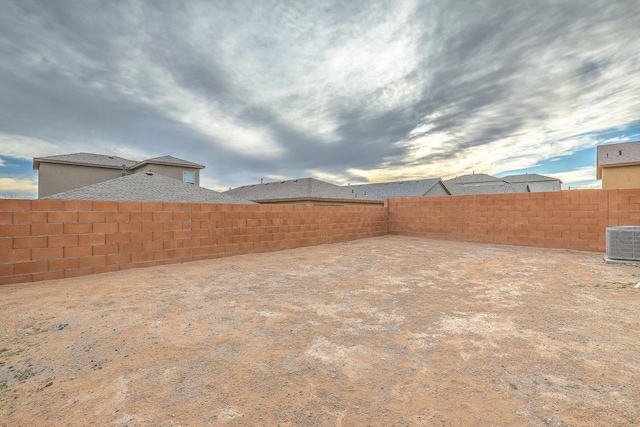 view of yard with a fenced backyard and central AC unit