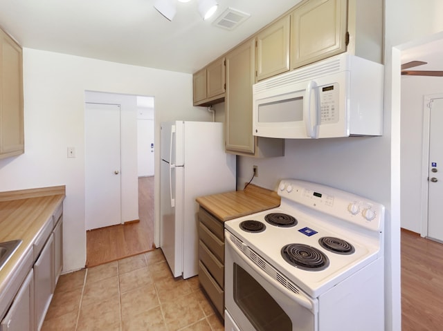 kitchen with white appliances, light countertops, visible vents, and light tile patterned floors