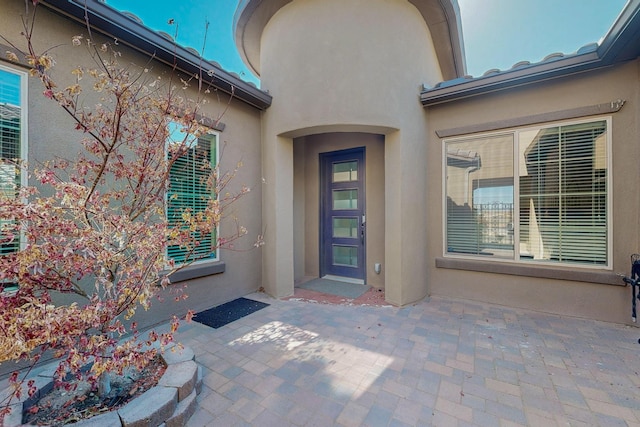 9020 Retablo Rd NW, Albuquerque, NM 87120 - doorway to property with stucco siding and a patio area