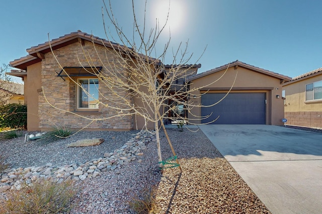 view of front of home featuring an attached garage, stucco siding, concrete driveway, stone siding, and a tile roof