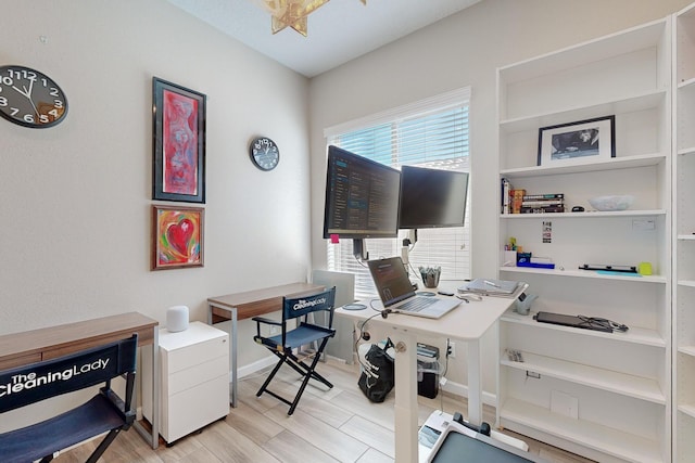 home office with baseboards and light wood finished floors