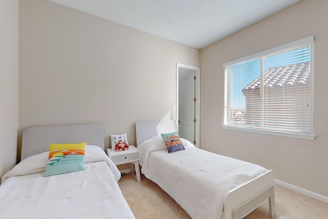 carpeted bedroom with baseboards and a textured ceiling