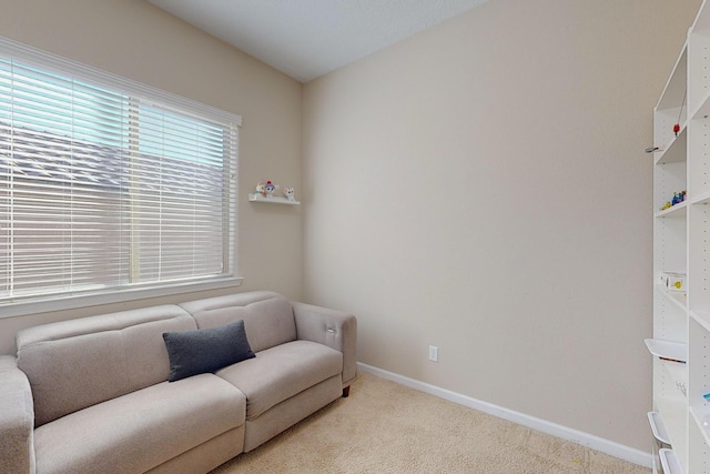 sitting room featuring light carpet and baseboards