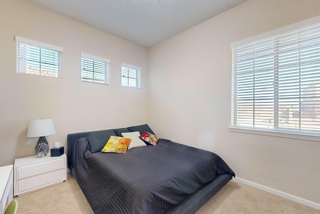 carpeted bedroom with baseboards and a textured ceiling