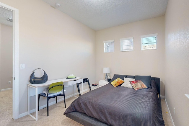 bedroom with carpet flooring, baseboards, and a textured ceiling