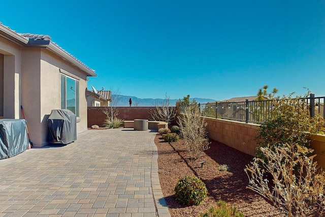 view of patio featuring a mountain view and a fenced backyard