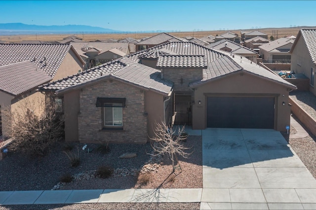 view of front of house with stucco siding, driveway, a tile roof, a residential view, and a garage