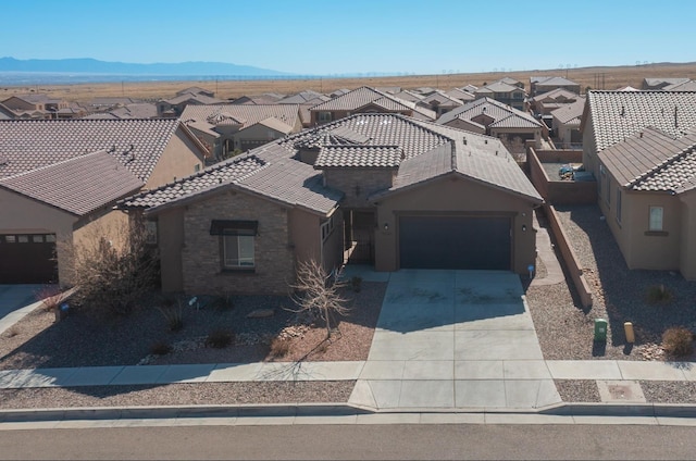 9020 Retablo Rd NW, Albuquerque, NM 87120 - view of front of home featuring a garage, concrete driveway, a tile roof, and a residential view