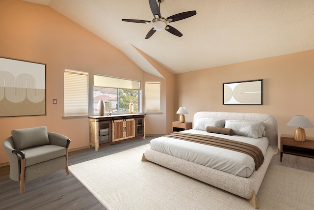 bedroom with ceiling fan, vaulted ceiling, and wood finished floors