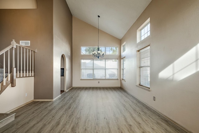 interior space featuring stairs, wood finished floors, visible vents, and a notable chandelier