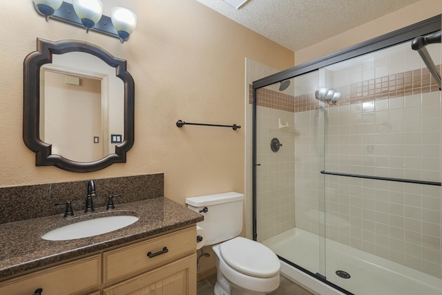 full bath featuring toilet, a textured ceiling, a shower stall, and vanity