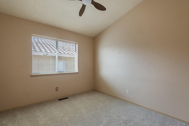 empty room with a textured ceiling, visible vents, a ceiling fan, vaulted ceiling, and carpet