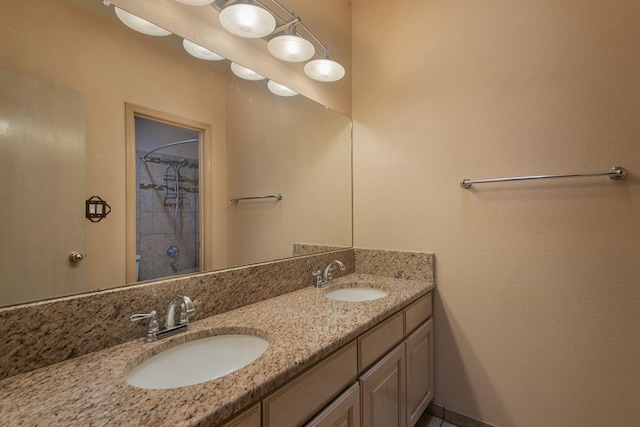 full bath with double vanity, walk in shower, and a sink