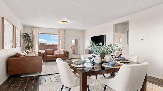 dining space featuring a textured ceiling, baseboards, and dark wood finished floors