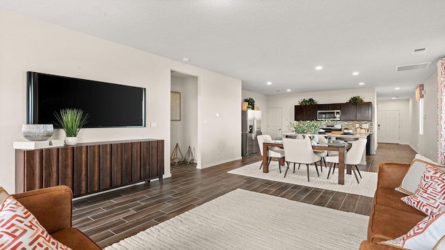 living room with baseboards, visible vents, wood tiled floor, and recessed lighting
