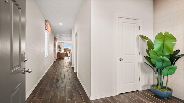 hallway with baseboards, wood tiled floor, and recessed lighting