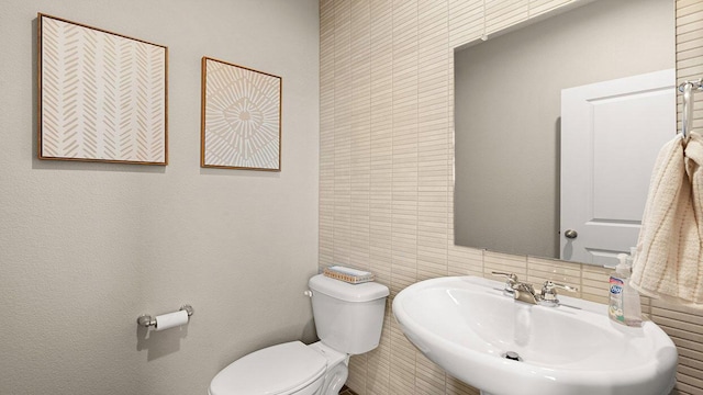 half bathroom featuring toilet and a sink