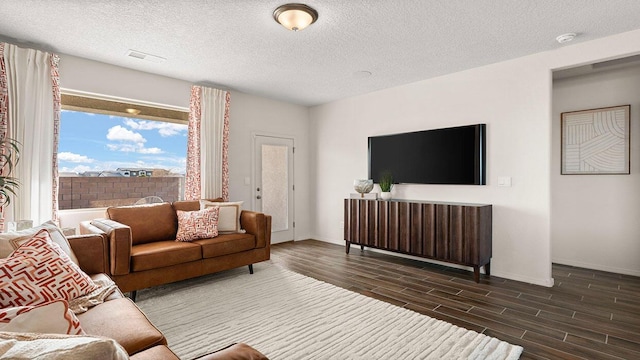 living area featuring visible vents, a textured ceiling, baseboards, and wood tiled floor