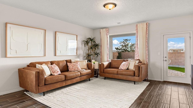 living room featuring a textured ceiling, baseboards, and wood tiled floor