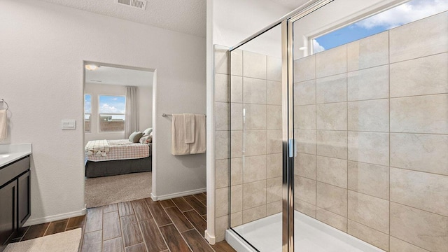 bathroom with a stall shower, wood tiled floor, vanity, and ensuite bathroom